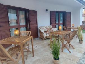 - deux tables et chaises en bois sur une terrasse dans l'établissement Villa Wunjo IUN R3267, à La Maddalena