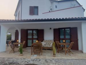 une terrasse avec des tables et des chaises dans une maison dans l'établissement Villa Wunjo IUN R3267, à La Maddalena