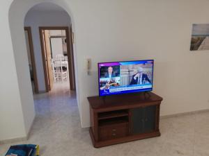 a flat screen tv sitting on top of a wooden stand at Apartamento Saint Martin in Armação de Pêra