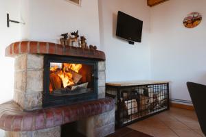 a brick fireplace with a fire in a living room at Jambrichova chata in Vysoké Tatry