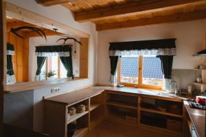 a kitchen with a counter and two windows at Jambrichova chata in Vysoké Tatry