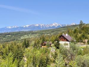 a house on a hill with mountains in the background at Jambrichova chata in Vysoké Tatry