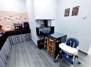 a room with a desk and chairs and a bed at DLuna Homestay Terengganu in Kuala Terengganu