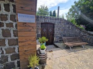 a building with a bench and a wooden door at Bényécske Chill & Spa in Erdőbénye