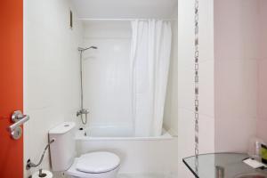 y baño con aseo, ducha y mesa de cristal. en Hotel DL Port, en Castellón de la Plana