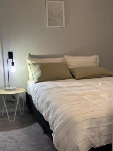 a bedroom with a bed and a table with a lamp at Petone - Central and Spacious in Lower Hutt