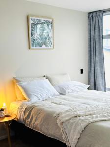 een slaapkamer met een bed met een foto aan de muur bij Petone - Central and Spacious in Lower Hutt