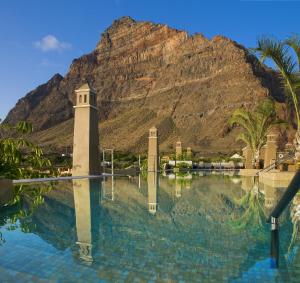 a pool of water with a mountain in the background at Hotel Playa Calera in Valle Gran Rey