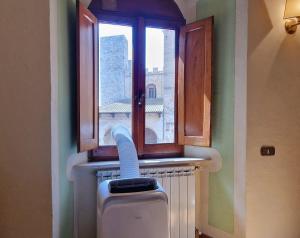 une fenêtre dans une pièce avec un radiateur sous celle-ci dans l'établissement Sangi Studio Apartment - with amazing view of the Duomo, à San Gimignano