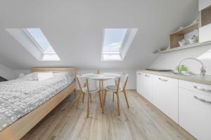 a bedroom with a bed and a table and chairs at GUDU apartments in Košice