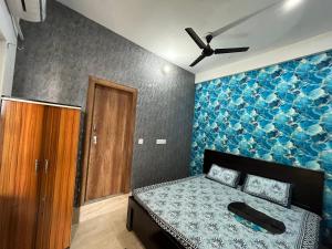 een slaapkamer met een bed en een blauwe muur bij Prabhu Sadan home stay in Govardhan