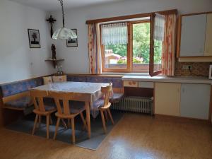 a kitchen with a table and chairs and a window at Haus an der Sonne FeWo 1 in Biberwier