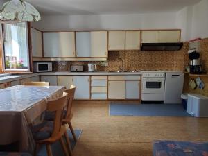 a kitchen with white appliances and a table with chairs at Haus an der Sonne FeWo 1 in Biberwier