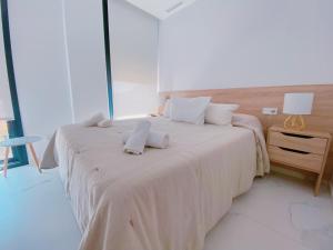 a bedroom with two beds with towels on them at Exclusivo Ático de Lujo en la Playa - holaVivienda Inmobiliaria in Denia +20 photos
