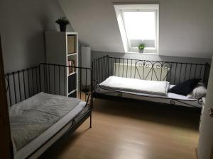 Un dormitorio con dos camas y una ventana. en Hof Landleben, en Dörpstedt