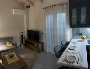 a living room with a couch and a television at The Old Stables Apartment in Vátos