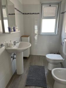 Baño blanco con lavabo y aseo en Nunziata Apartment, en Nunziata