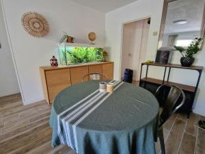 ein Esszimmer mit einem Tisch und einem Aquarium in der Unterkunft Bel appartement avec jardin in Aix-en-Provence
