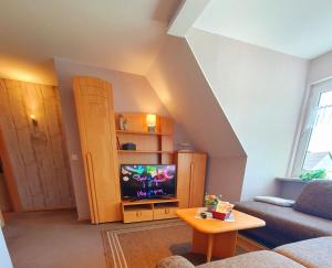 a living room with a couch and a tv at Kansteinblick Weserbergland in Salzhemmendorf