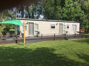 a cabin with a deck and a green umbrella at Holiday Home Klavas in Sigulda