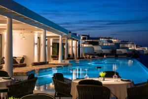 a resort with a swimming pool at night at Cresanto Luxury Suites in Imerovigli