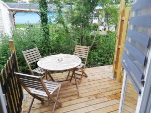 een tafel en twee stoelen op een houten terras bij Hébergements sur camping au bord de la mer in Crozon