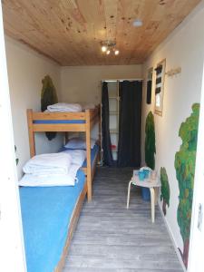 een kamer met 2 stapelbedden en een tafel bij Hébergements sur camping au bord de la mer in Crozon