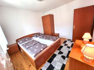 a small bedroom with a bed and a desk at Zlata Apartment in Fužine