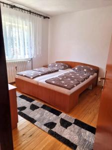 a bedroom with a large bed in a room at Zlata Apartment in Fužine
