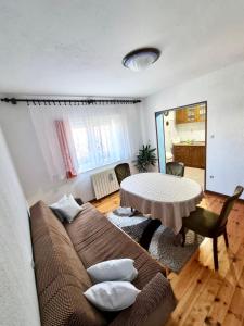 a living room with a couch and a table with pillows at Zlata Apartment in Fužine