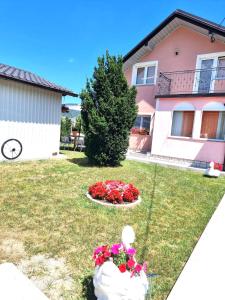a house with a flower bed of flowers in the yard at Zlata Apartment in Fužine