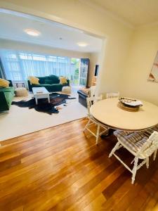 uma sala de estar com uma mesa e um sofá em Rosedale Retreat em Invercargill