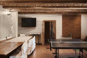 a room with a ping pong table and a tv at Kroņakrogs in Slavēka