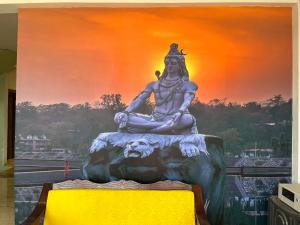 una grande statua di fronte a un dipinto di Prabhu Sadan home stay a Govardhan