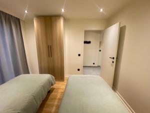two beds in a small room with a hallway at Malpertus in Bredene