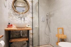 a bathroom with a shower with a sink and a mirror at KT Villa in Troulos