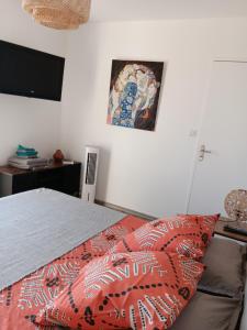 1 dormitorio con 1 cama y una pintura en la pared en Chez kary, en Saint-Cyr-sur-Mer
