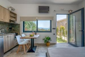 cocina y comedor con mesa y sillas en Cavos Luxury Apartments en Kíssamos