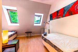 a bedroom with two beds and two windows at Lovely 4-bedroom flat in historical center with stunning view in Trenčín