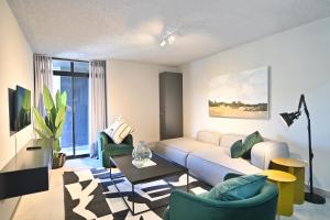 a living room with a couch and two chairs at Circa Aparthotel by Totalstay in Pretoria