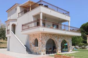 ein großes weißes Gebäude mit Balkon oben in der Unterkunft KT Villa in Troulos