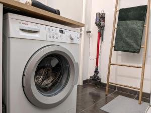 a washing machine in a room with a ladder at La Terrasse du tramway, Parking, 30min de Paris in Bezons