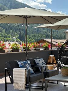 a patio with two chairs and an umbrella at Si Mezzana Home in Mezzana