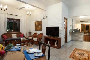 a living room with a couch and a tv at ama stays & trails - Dulwich Park View in Panchgani
