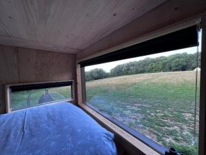 una camera da letto con finestra affacciata su un campo di Hop and hare farm a Hastings