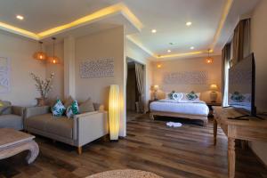 a bedroom with a bed and a couch and a table at Vannee Golden Sands Beachfront Resort in Haad Rin