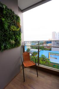 uma cadeira num quarto com uma grande janela em Calma 31 Apartment em Makassar