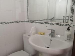 a bathroom with a toilet and a sink and a mirror at Sol y playa in Conil de la Frontera