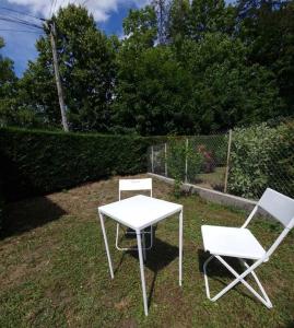 2 chaises blanches et une table et des chaises blanches dans l'établissement Appartement aux portes de Genève, à Collonges-sous-Salève