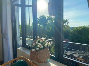 una ventana con una cesta de flores en el balcón en Hue Sweethouse 2 Homestay en Hue